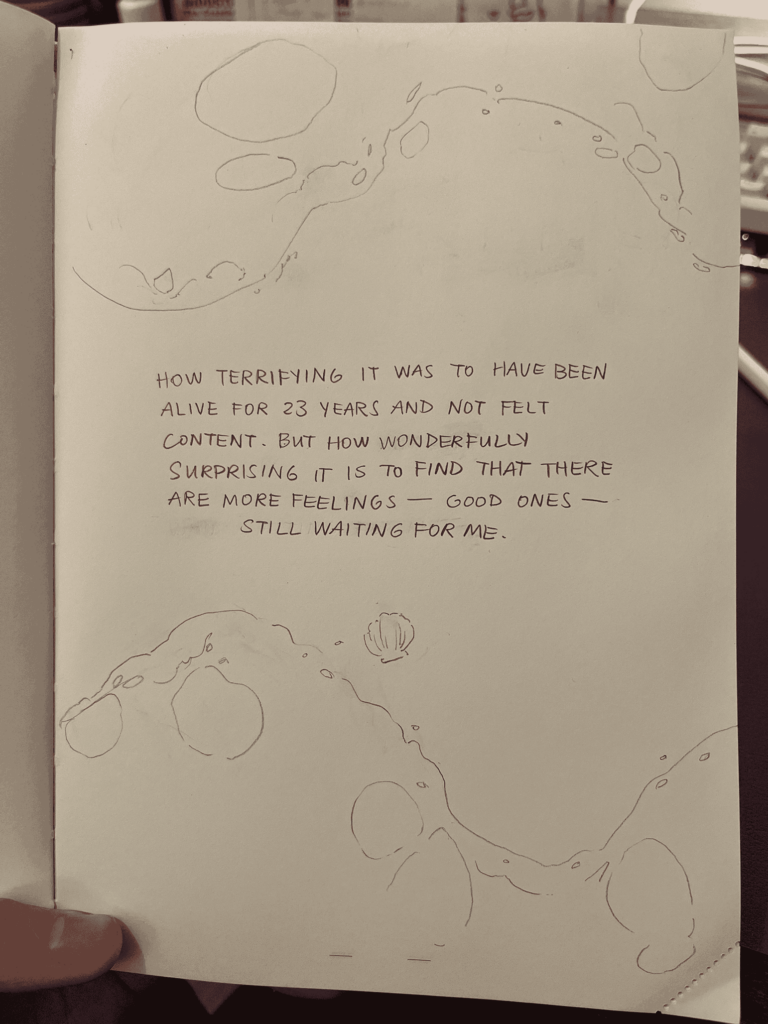 Page 4 of a comic drawn on paper. The text says "How terrifying it was to have been alive for 23 years and not felt content. But how wonderfully surprising it is to find that there are more feelings -- good ones -- still waiting for me". There are drawings of waves receding away from the text.